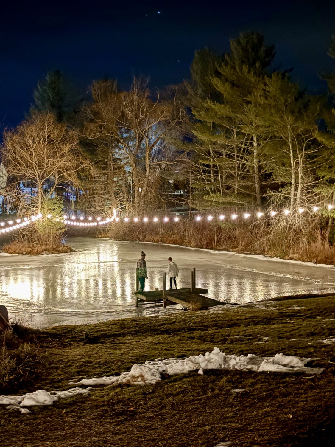The skating pond at night, strung with lights